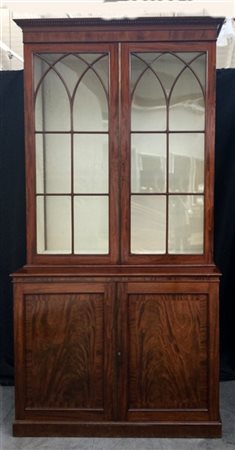 Mobile a due corpi lastronato in mogano, parte inferiore a due sportelli, parte