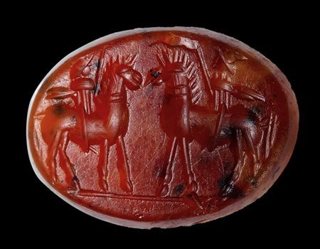 A roman agate carnelian intaglio with dark inclusions. Two horsemen.