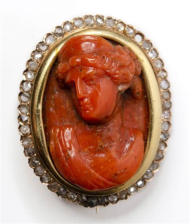 A postclassical coral cameo mounted in a gold broch with brillants. Bust of a woman.