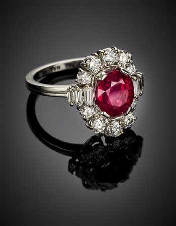 Anello in oro bianco con diamanti rotondi e baguette a contornare un rubino ova