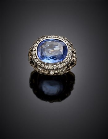 Anello in oro giallo e argento cesellati e traforati con zaffiro a cuscino di c