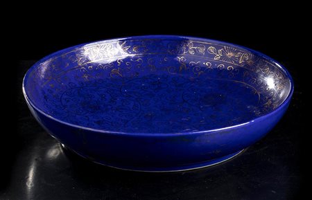 PIATTO IN PORCELLANA CON INVETRIATURA BLU E DECORO A ORO 
Cina, dinastia Qing, marchio e periodo Yongzheng