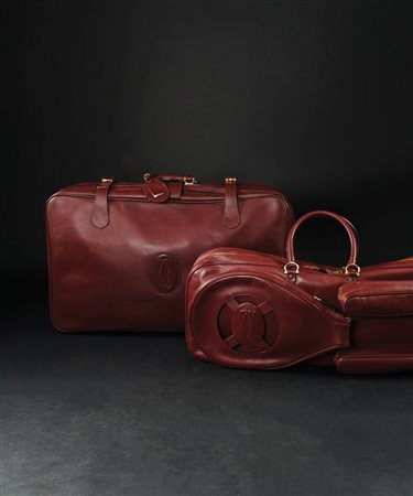 Cartier una valigia e una borsa da tennis in pelle rossa con logo; complete...