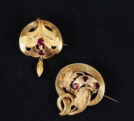Due spille in oro 9kt. e granati, cesellate a motivi fogliati. XIX secolo, l....