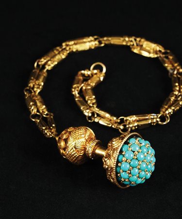 Pendente in oro giallo decorato con una semisfera tempestata di turchesi...