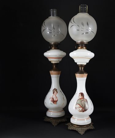 Coppia di lumi a petrolio con fusto in opalina bianca decorato...