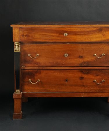 Commode impiallacciata in mogano. Fronte a tre cassetti delimitati da due...