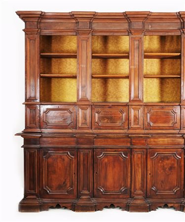 Mobile-libreria a due corpi di noce di linea architettonica. La parte...