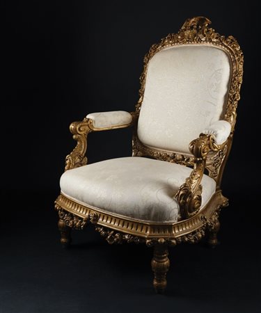 Poltrona in legno dorato. Dossello arcuato riccamente scolpito a sequenza di...