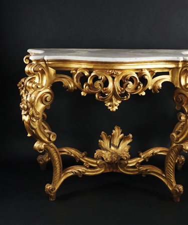 Console in legno dorato. Fascia centinata scolpita a grandi foglie...