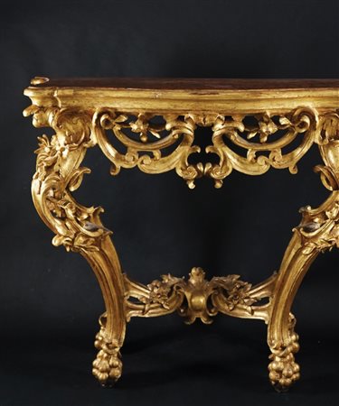 Console in legno dorato. Piano sagomato laccato a finto marmo; fascia...