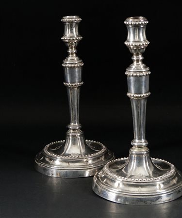 Coppia di candelieri in argento. Stelo e bobèche scanalati cesellati a...