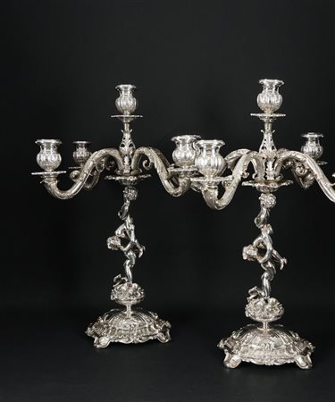 Coppia di candelabri in argento a cinque luci ciascuno emergenti da quattro...