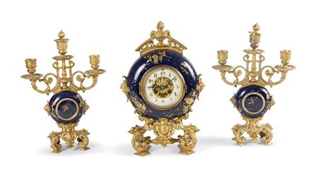 TRITTICO DI OROLOGIO E CANDELIERI Trittico composto da un orologio e due...