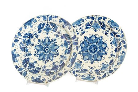 Coppia di antichi piatti in ceramica bianca e blu a motivi floreali