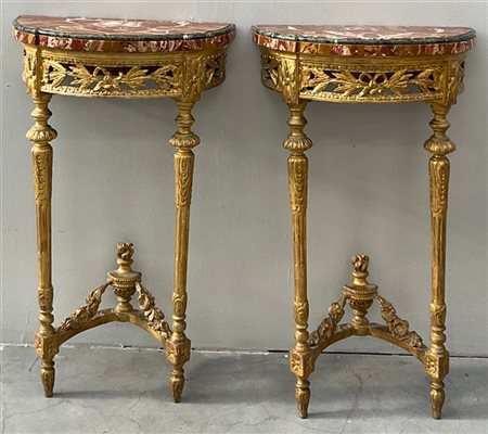 Coppia di consolles a mezzaluna in legno intagliato, traforato e dorato a motiv