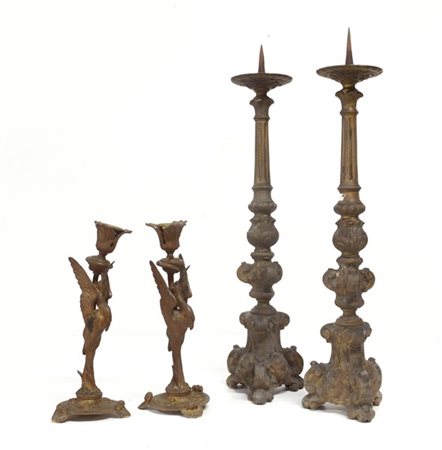 Lotto di due coppie di candelieri; una coppia con base tripode decorata da cherubini e volute (h cm 58), l'altra con fusto decorato da airone tutto tondo (h cm 29) (difetti e mancanze)
