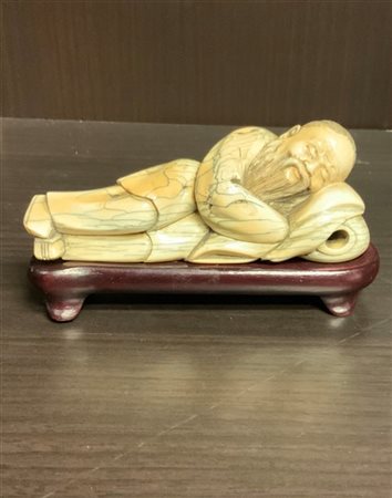 Figura in avorio raffigurante saggio dormiente, base in legno
Cina, inizi sec.