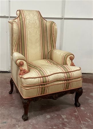 Poltrona ad orecchioni con fascia e piedi sagomati e intagliati, rivestita in t