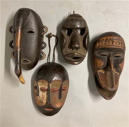 Arte africana, lotto di quattro maschere in legno scolpito e pigmenti di etnie