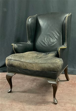 Poltrona a orecchioni con gambe in legno e imbottiture rivestite in pelle nera