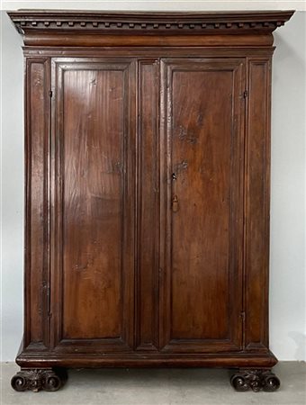 Antico armadio in noce a due ante riquadrate, cimasa decorata a dentellature, p