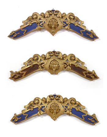 Gruppo di tre fregi in legno scolpito, laccato e dorato, decorati a volute, mot