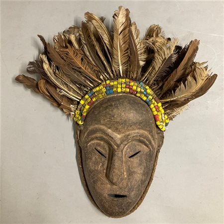 Arte africana, maschera in legno sormontata da file di perline e penne di galli