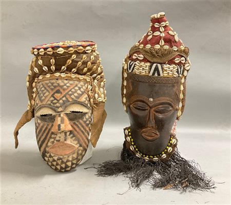 Arte africana, lotto di due maschere in legno dipinto con copricapi in tessuto