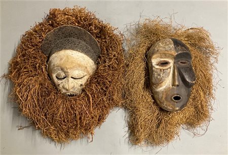 Arte africana, lotto di due maschere in legno scolpito e dipinto contornate da
