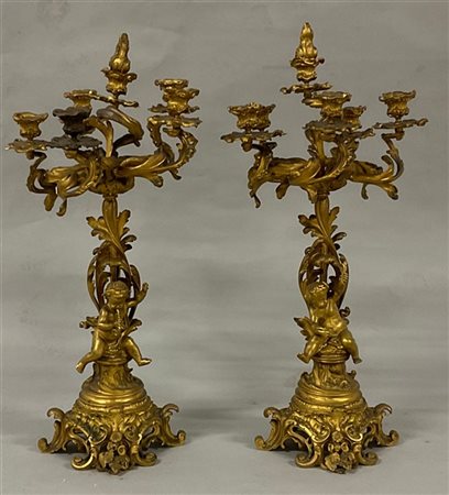 Coppia di candelabri in bronzo dorato a sei luci decorati con amorini allegoric