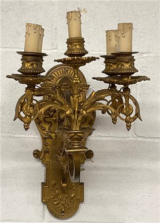 Applique a cinque luci in bronzo dorato con decoro a foglie, volute e mascheron