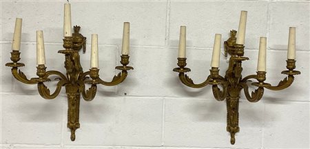 Coppia di appliques a cinque fiamme in bronzo dorato decorate a teste di ariete