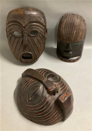 Arte africana, lotto di tre maschere in legno scolpito e pigmenti, etnie differ