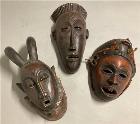 Arte africana, lotto di tre maschere in legno scolpito e tracce di pigmenti (h