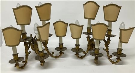 Coppia di applique a cinque fiamme in bronzo dorato e cesellato a volute foglia