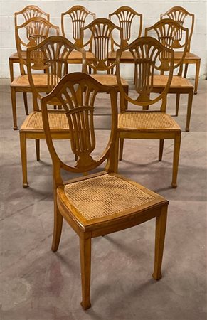 Gruppo di dieci sedie in legno chiaro con schienale a giorno a forma di "scudo"