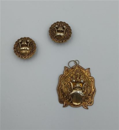 Lotto composto da unn paio di orecchini e un pendente in metallo di origine ori