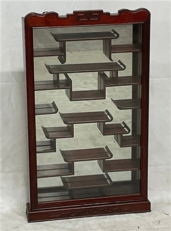 Vetrinetta pensile in legno intagliato con ripiani sagomati su fondo a specchio