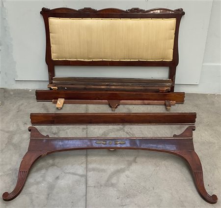 Letto con testata intagliata a riccioli con motivi stilizzati pediera con monta