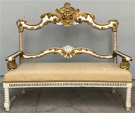 Antico divano in legno intagliato laccato e dorato. Schienale a giorno di forma