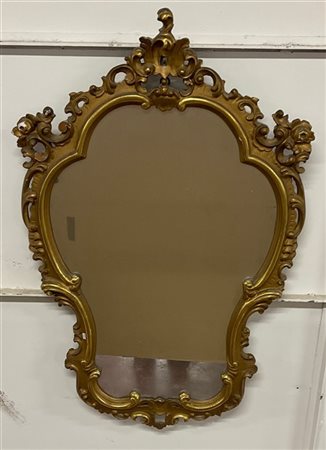 Specchiera di forma sagomata in legno dorato e intagliato a volute e fiori (cm