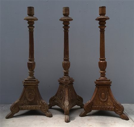 Gruppo di tre torcere in legno intagliato con base tripode e fusto scanalato.(h