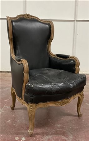 Poltrona di forma mossa in legno intagliato con schienale sormontato da fiori,