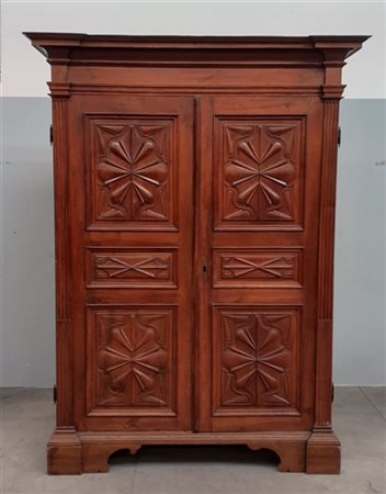 Armadio a due ante pannellate con montanti squadrati, cappello aggettante, pied