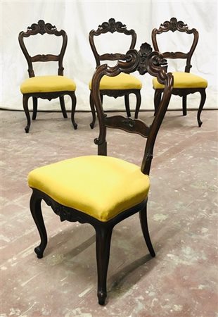 Gruppo di quattro sedie in noce con schienale a giorno intagliato a valva di co