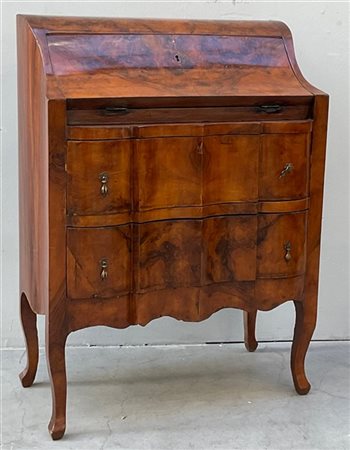 Piccola ribalta lastronata in radica di noce con fronte mosso a due cassetti (c