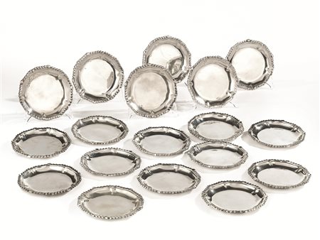 Diciotto piattini da pane, in argento, bordo sagomato e lavorato a...
