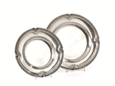 Due vassoi, in argento, di forma circolare con bordi lavorati a baccellature...