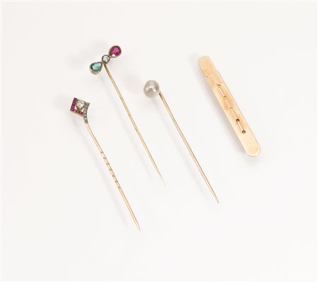 Tre spille da cravatta in oro giallo e pietredecorate rispettivamente da una...